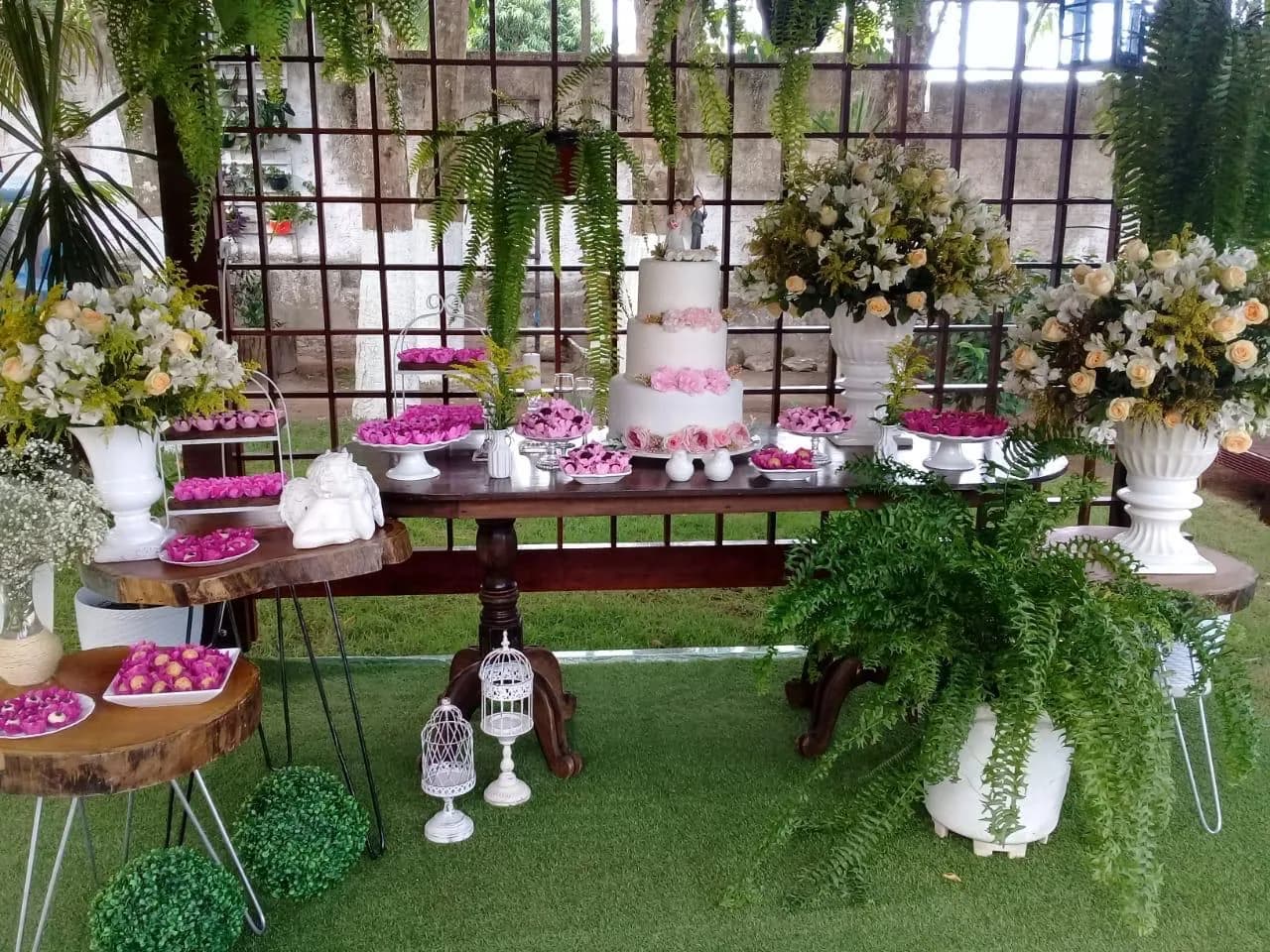 Vista aberta da mesa de doces e do gramado preparado para a festa