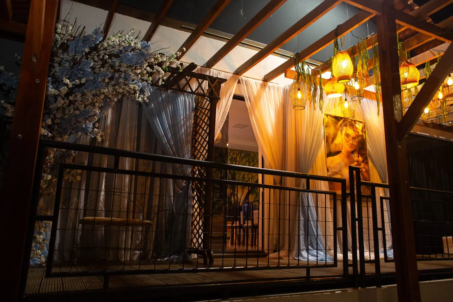 Terrace with blossoming branches, rattan lamps and sheer curtains