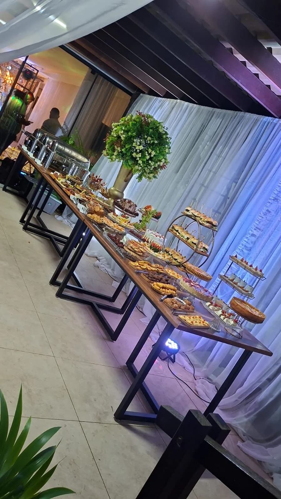 Buffet table set up in the hall, with a floral arrangement and platters of sweets and savouries
